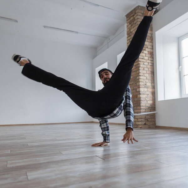 Lifestyle dancing. Handsome young man dancing break dance indoors