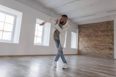 KukuIeta ve yırtık kot bir dans stüdyosunda dans şık bir ceketli moda yakışıklı genç dansçı çocuk