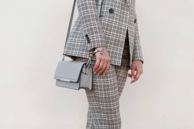 Bir moda çanta ve şık kareli takım elbise ile güzel kız.