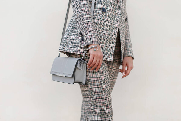 Красивая девушка с модной сумкой и стильным клетчатым костюмом
.