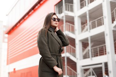 Şehirde bir vintage moda ceket güneş gözlüklü genç oldukça stil sahibi kız yürüyor