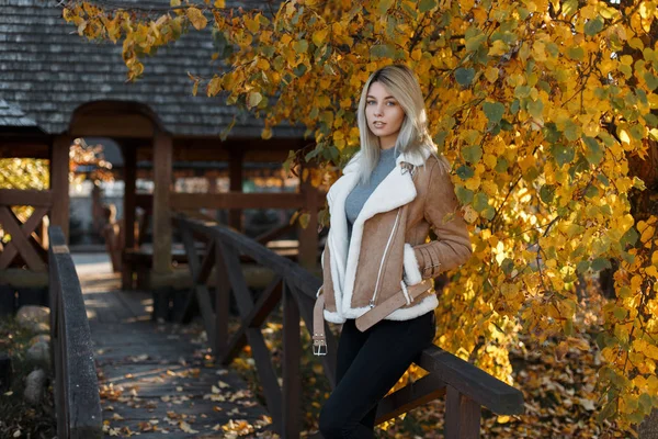 一个美丽的金发碧眼的女孩的肖像站在公园里 穿着米色时尚夹克的美丽年轻女子 秋天的季节 女性时尚的概念 — 图库照片
