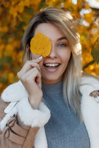 一个快乐美丽的年轻女子的肖像与黄叶在户外在公园中的金色叶子在一个良好的心情 迷人的女孩 漂亮的笑容秋天 — 图库照片