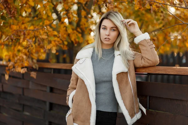 现代年轻迷人的女孩模型在一个时尚的 Demi 季节夹克与白领摆在木墙在一个黄色黄金公园 女性季节性秋季时尚 — 图库照片