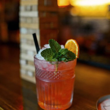 Masada, portakal dilimleri ve nane ile dekore edilmiş meyve alkollü kokteyli votka ile buz ve doğal suyu ilavesi ile beyaz rom ile bir kristal cam olduğunu. Gece kulübü hayatı. 