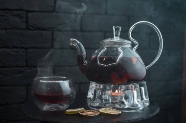 Sıcak bitkisel siyah çay nane yaprakları ve cam vintage çaydanlık yanındaki bir cam bardak zencefil ile ahşap bir masa bir kafede üzerinde duruyor. Akşam rahat. Çay töreni.