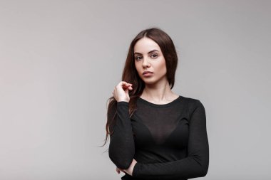 Bir şık şeffaf şık siyah t-shirt beyaz arka plan için stüdyoda poz içinde uzun güzel kahverengi saçlı seksi genç çekici kadın. Şaşırtıcı kız modeli