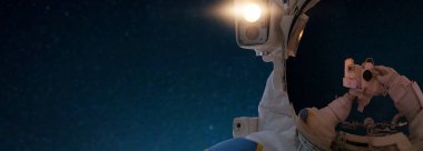 Astronot uzayda bir selfie fotoğraf makinesini alır. Spaceman uzayda yıldız arka planı yayılıyor. Yakın çekim.