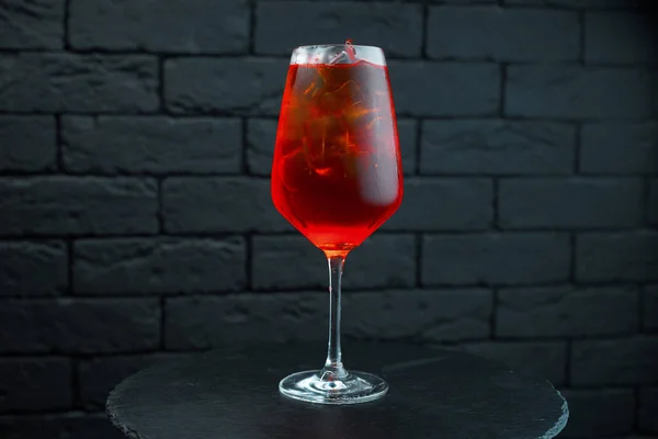 一个不寻常的甜美味的红色鸡尾酒在一个玻璃与伏特加与天然果汁 加入石榴糖浆和白朗姆酒是在酒吧的桌子上 饮料是冰镇的 — 图库照片