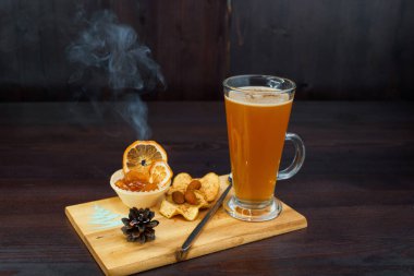 Zencefil ve diğer yararlı maddeler ile altın rengi kokulu sıcak ısınma bardak bir kafede bir ahşap tahta üzerinde duruyor. Kayısı ve kuru meyve ile içki servis