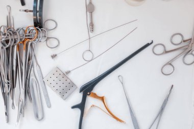 Mikrocerrahi için paslanmaz çelik krom kaplama aygıtlar: neşter, spatula, forseps, forseps, amp, cerrahi cımbız ve makas, masanın üzerinde bulunan.