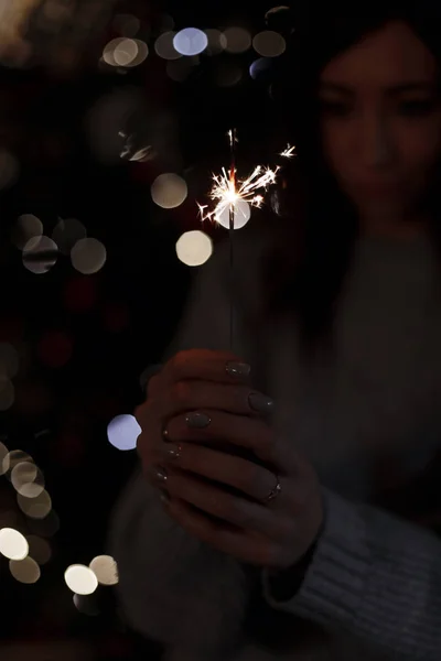 Young Woman Knitted Sweater Holds Sparkling Amazing Sparklers Dark Room — Stock Photo, Image