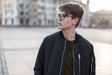 Şık gözlük yakışıklı hipster genç adamla şehirde sokakta şık bir dış giyimi şık bir saç modeli. Çekici şehir şık adam.