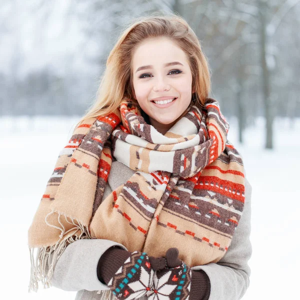 公園で雪に覆われた木の背景にスタイリッシュな冬服で美しい笑顔で面白い幸せな若い女 かわいい女の子の楽しみは屋外の時間を費やしてください — ストック写真