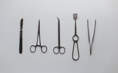 Gri metal tıp aletleri Nöroşirürji ameliyathane beyaz bir tablo için. Yukarıdan görüntülemek.