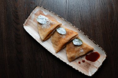 İştah açıcı altın ince krep tatlı çilek reçeli ile krema şeker bir restoranda bir tabakta ile dekore edilmiştir. Lezzetli tatlı çay için. Yukarıdan görüntülemek.