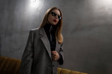 Genç çekici hipster kadın vintage şık kareli ceket kırmızı dudaklar ile şık siyah gömlekli bir küpe burnundaki ile olağandışı şık bardaklarda kafede durumda. Şık kız.