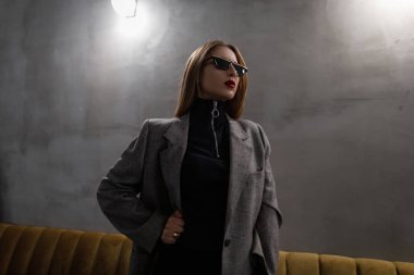 Serin moda hipster siyah t-shirt bir kafede poz içinde deldi burunlu kırmızı dudaklar ile vintage retro tarzı kareli ceket siyah şık güneş genç kadında. Modern kız punk.