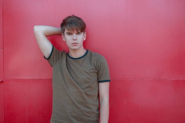 Stüdyo pembe bir arka planda poz trendy T-shirt bir moda saç modeli ile Amerikan şık yakışıklı genç adam. Modern adam. Metin için boş alan.