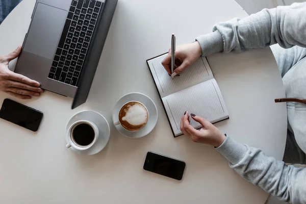 I colleghi stanno lavorando a distanza su un progetto creativo in un ambiente informale. Lavoro di squadra. Incontro d'affari di due persone di successo. Pausa caffè. Vista dall'alto . — Foto Stock