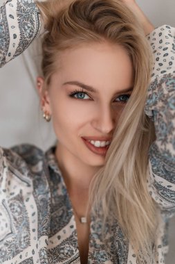 Bir desen ile şık bir gömlek sarı saçlı seksi dudaklar ile mavi gözleri ile güzel bir gülümseme ile mutlu bir genç kadının portre. Neşeli pozitif kız modeli. Bir kadın yüz closeup.