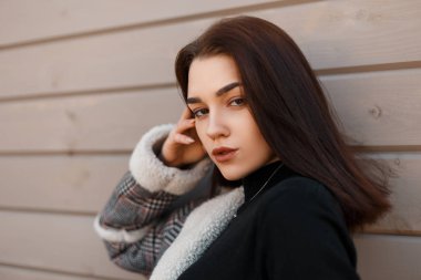 Modern ahşap vintage duvar açık havada yakın siyah moda gömlek şık gri damalı ceket çekici genç esmer kadın. Güzel seksi kız modeli. Bir kadının yüzünün portresi.