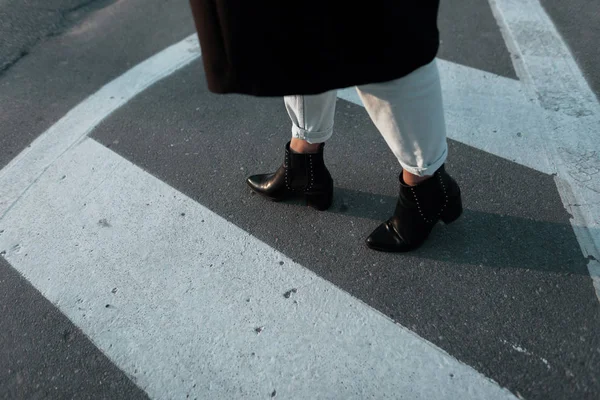 Γυναικεία πόδια σε κομψά κομμένα τζιν σε vintage δερμάτινα παπούτσια μαύρο τακούνι σε ένα δρόμο της πόλης. Μοντέρνα κομψά casual ρούχα. Λεπτομέρειες για την καθημερινή εμφάνιση της άνοιξης. Μόδα του δρόμου. Γκρο πλαν. — Φωτογραφία Αρχείου