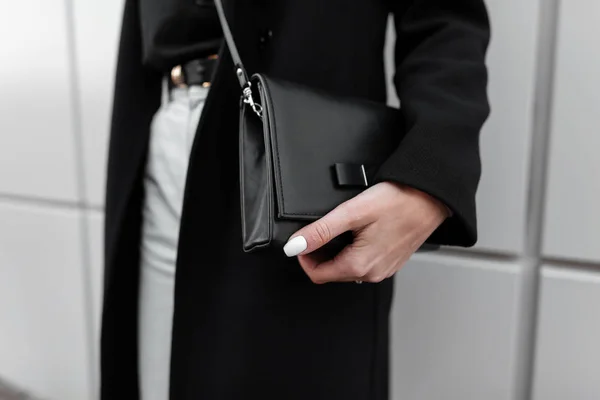 세련 된 여성의 블랙 가죽 세련 된 가방입니다. 세련된 옷을 입은 현대의 어린 소녀. 패션 봄 - 가을. 새 컬렉션입니다. 클로즈업. — 스톡 사진