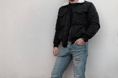 Şık bir siyah t-shirt modern bir binanın yakınında poz mavi moda kot beyaz yakalı siyah şık bir ceket şık modern genç adam. Erkek giyiminin yeni koleksiyonu. Close