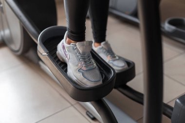 Şık beyaz spor ayakkabı kadın bacaklar bir fitness stüdyosunda bir step simülatörü üzerinde yürüme standı. Genç kadın modern bir spor salonunda antrenman lar. Spor ve sağlık kavramı. Close.