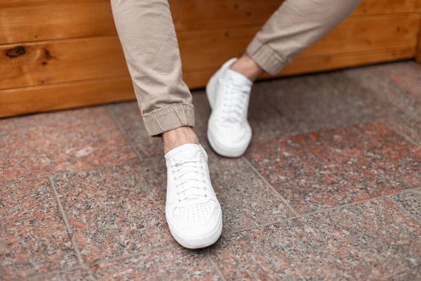 Модные мужские белые кожаные кроссовки. Стильная мужская обувь. Свободный дизайн. Крупный план мужских ног . — стоковое фото
