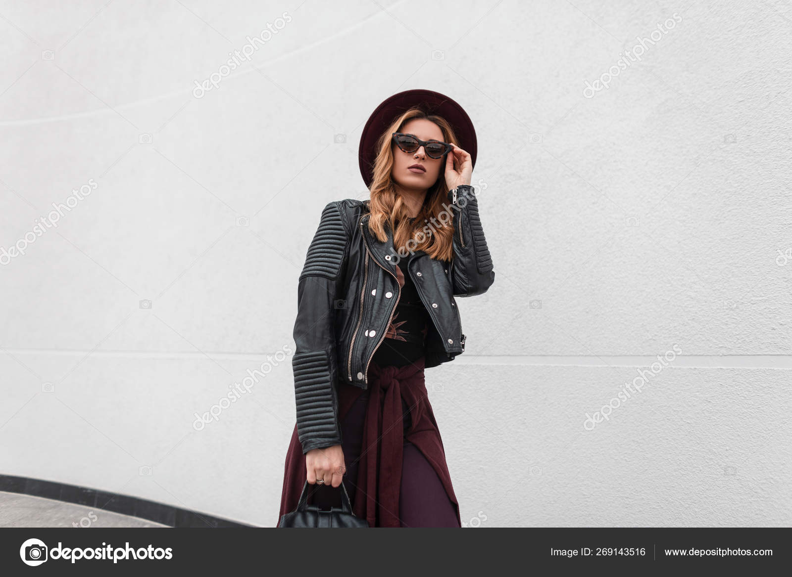 Mujer joven moderna urbana en ropa de moda con una mochila de cuero en un
