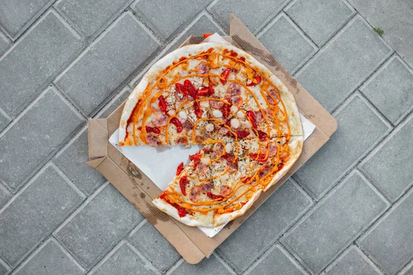 La pizza caliente sabrosa con la salchicha con la salsa de mostaza con los tomates y las hierbas picantes sobre el papel sobre la baldosa gris. Vista superior de la deliciosa pizza. Alimentos gourmet . — Foto de Stock