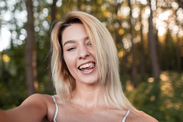  Beautiful happy young fashionable woman in a pink dress shows tongue ...