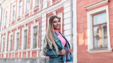 Glamour mutlu genç kadın bir yaz günü sokakta yürüyüş şık bir pembe üst vintage pembe şort uzun saçlı sarışın. Gülümseme ile sevimli neşeli kız model