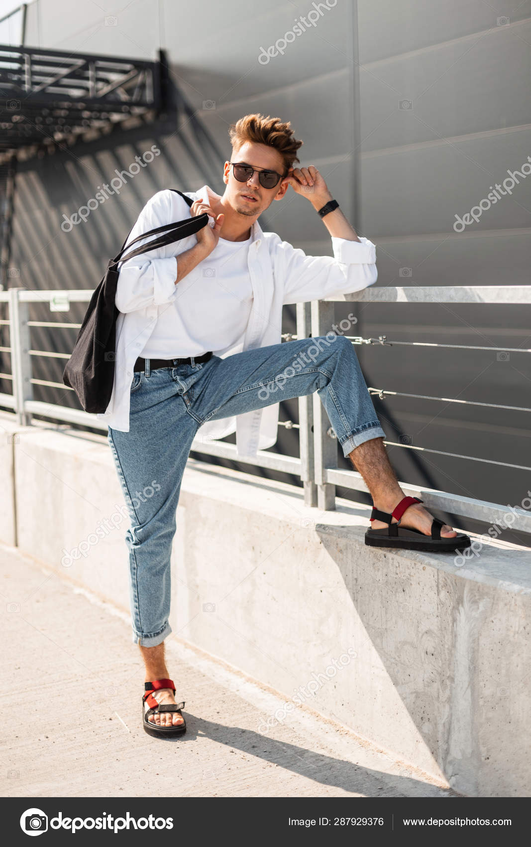 El hombre hipster joven de moda en ropa elegante blanca y de