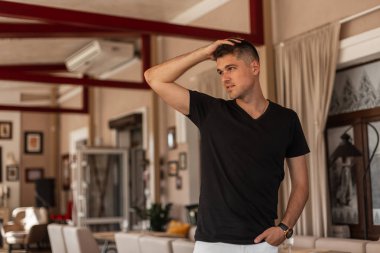 Şık siyah yazlık giysiler moda genç adam modeli saç düzleştirmek. Eski bir kafede dinlenmiş çekici bir adam. Şık erkek giyim.