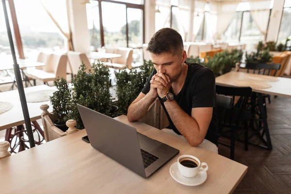 Profesionální mladý pohledný obchodník pracující na přenosném počítači na internetu s kreativním projektem. Ten Návrhář sedí a přemýšlí o novém projektu vzdáleně v kavárně. — Stock fotografie