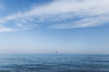 Güzel beyaz bulutları ve ufukta bir yat ile mavi bir gökyüzü ile açık mavi okyanus. İspanya'da seyahat ediyor. Cennet.