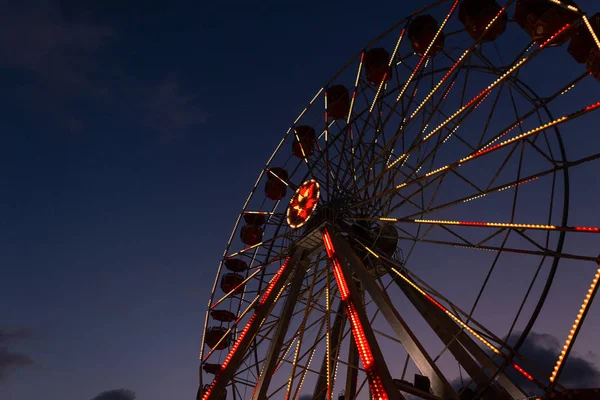 Unterseite Ansicht auf Riesenrädern mit schönen hellen Lampen auf einem Hintergrund ein dunkelblauer Himmel. Oldtimer-Riesenrad am Abend. — Stockfoto