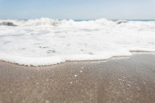 Vista desde la orilla en un océano agitado con espuma blanca con olas con cielo azul claro en un día soleado de verano. Hermoso paisaje marino. España . —  Fotos de Stock