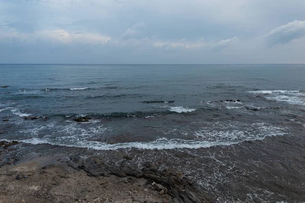 Mar con olas y rocas con cielo y nubes. Paisaje marino por la noche. Composición natural. España . — Foto de Stock