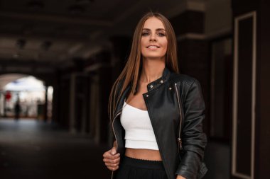 Şık giyinmiş çekici genç bir kadın şehirde dolaşıyor. Hoş bir gülüşü olan pozitif kız modeller, sonbahar günlerinde şehirde bir hafta sonunun tadını çıkarırlar. Şık kadın kıyafetleri..