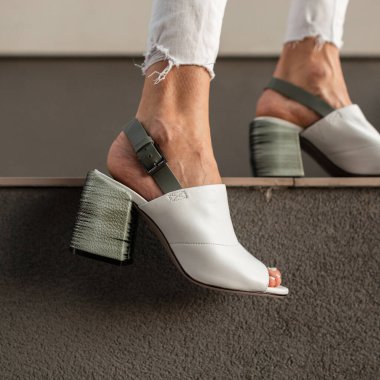 Modaya uygun beyaz deri ayakkabıların kadın bacaklarında yakın plan çekimi..