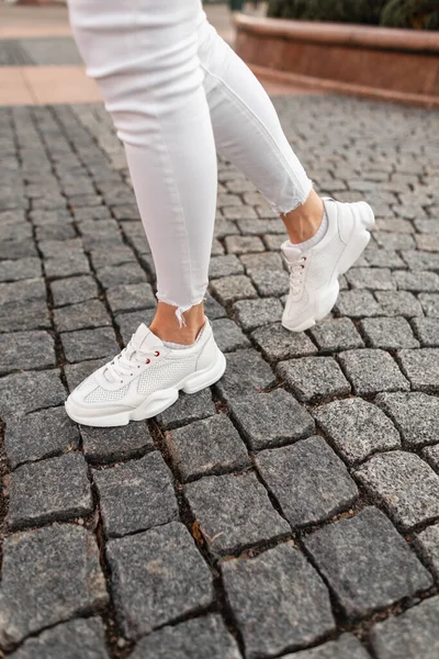 Fashion Γυναικεία Πόδια Λευκά Sneakers Και Denim Παντελόνι Πέτρινο Δρόμο — Φωτογραφία Αρχείου