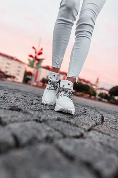 Mode Vrouwelijke Benen Witte Sneakers Denim Broek Een Stenen Weg — Stockfoto