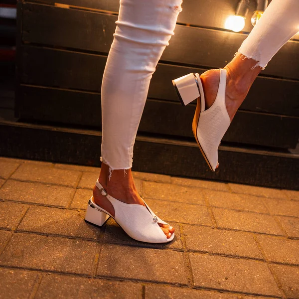 夜市でポーズをとるファッショナブルな革の靴でスタイリッシュな女性 — ストック写真