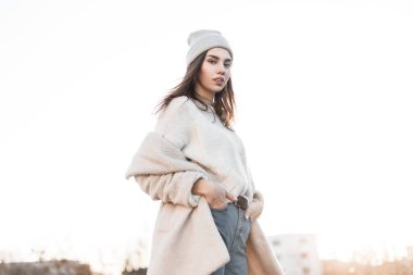 Güneşli bir kış gününde dışarıda poz veren, kalın kazaklı, şık, sade kürklü güzel bir kadın. Çekici, şık, modaya uygun, açık hava kıyafetleri içinde bir kız model..