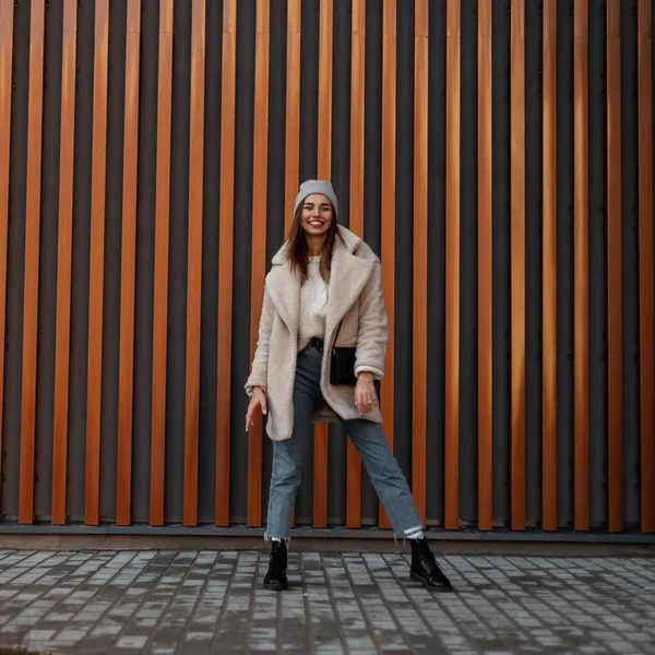 Premium Photo  Trendy beautiful young woman in fashionable casual wear  outfit with a leather jacket with bellbottom highwaisted jeans and white  sneakers walks near a red brick store building