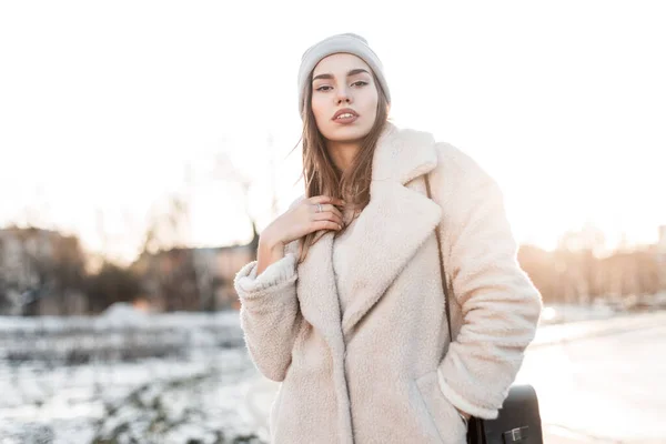 입술을 귀여운 여자가 겨울에 배경에 핸드백이 코트를 귀여운 소녀는 야외에서 — 스톡 사진